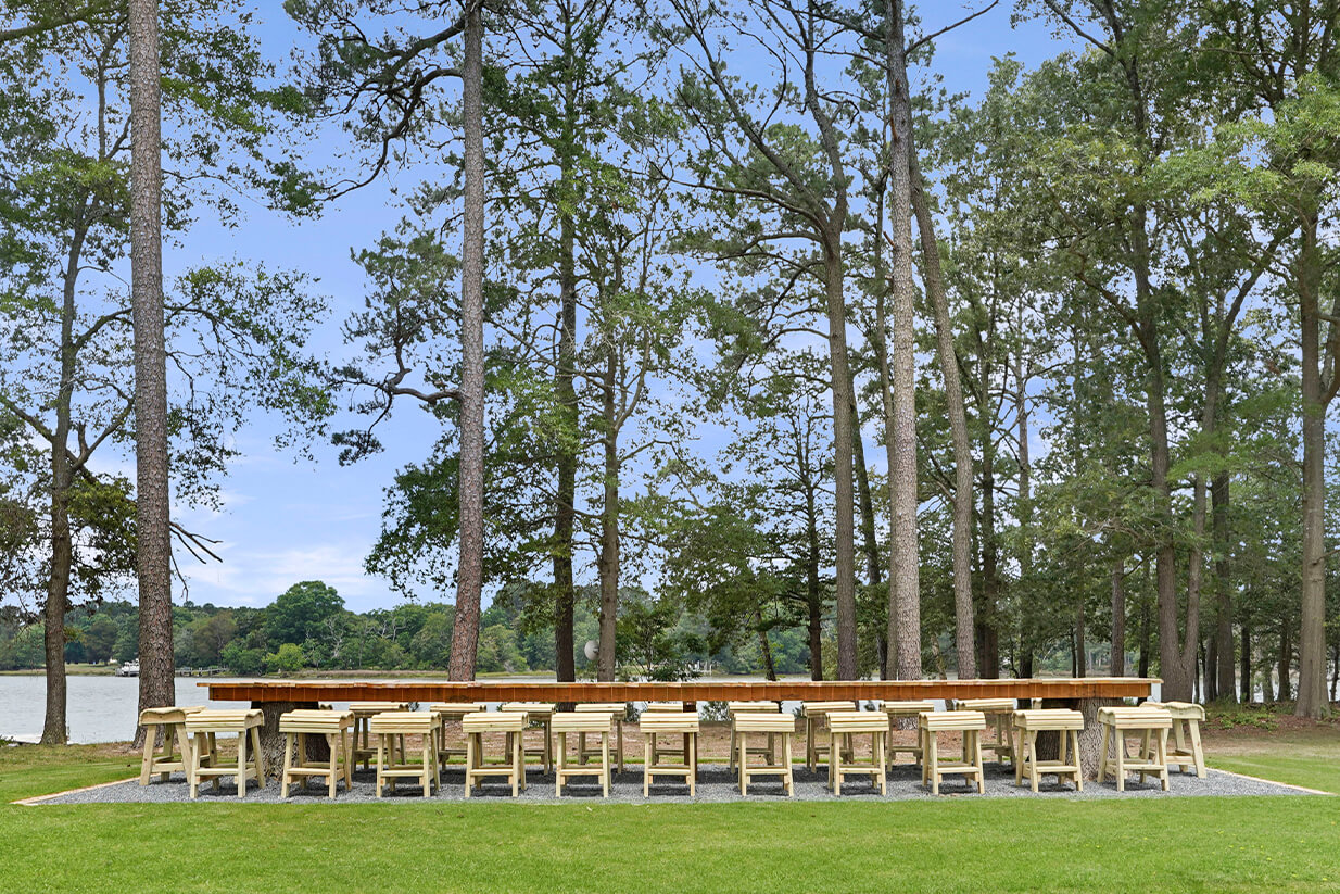 seating around a large outdoor dining table with waterfront view