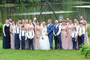a wedding party poses on the lawn in front of the vaux hall manor house