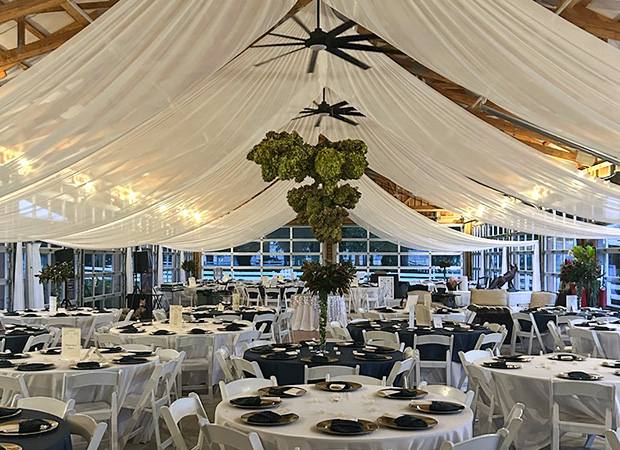 a farm themed pavilion filled with tables set for a wedding party